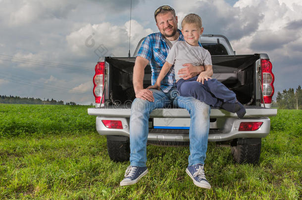 父亲和他的儿子坐在汽<strong>车后备箱</strong>上