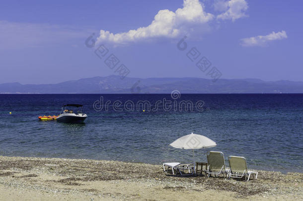 沙滩上的沙滩椅和雨伞。 休息、放松、度假、水疗、度假的概念。