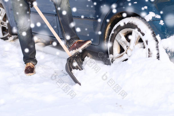 车旁铲雪男子特写