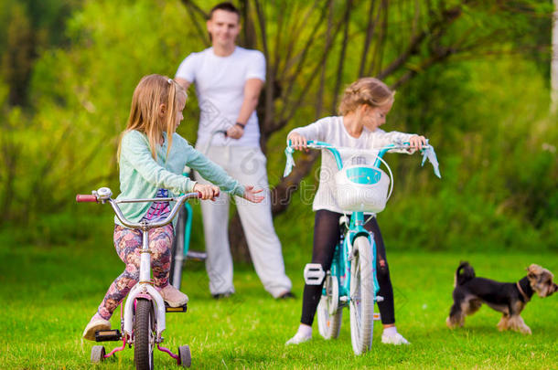 一个年轻的父亲和小孩子骑自行车的家庭