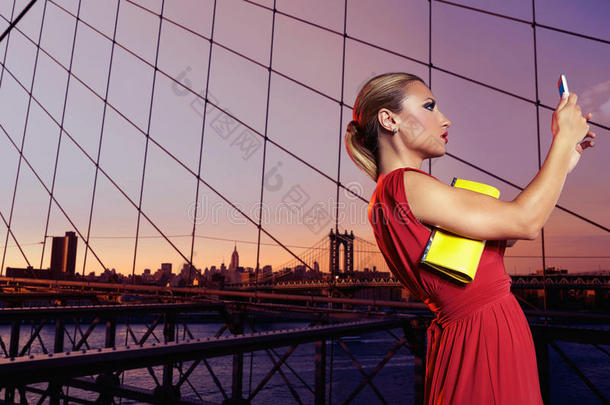 布鲁克林大桥的金发旅游女孩自拍照片