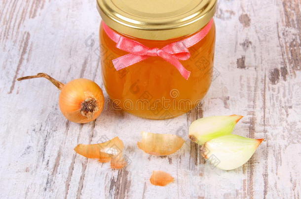 玻璃罐中的新鲜有机<strong>蜂蜜</strong>和木制背景上的洋葱，健康的<strong>营养</strong>和增强免疫力