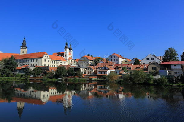 一个童话城堡和古老的城镇，<strong>美丽</strong>的<strong>湖畔</strong>镜子反射在蓝色阳光明媚的天空下的光滑的水面上