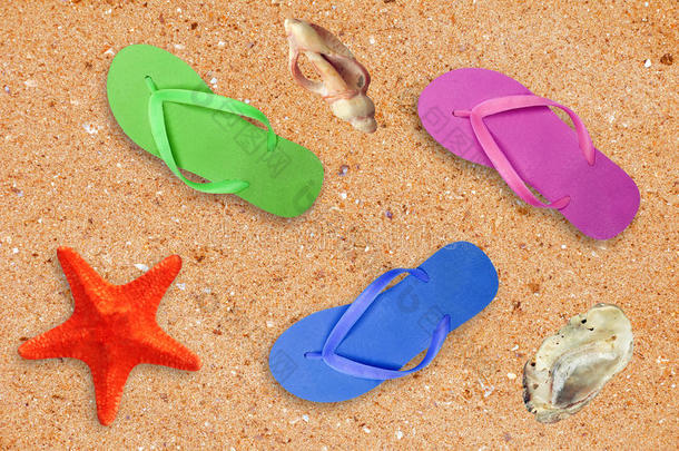 五颜六色的<strong>沙滩鞋</strong>和海星在沙滩背景上