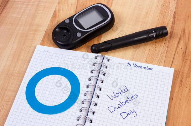 血糖仪，<strong>世界糖尿病日</strong>写在笔记本和蓝色圆圈，<strong>糖尿病</strong>的象征