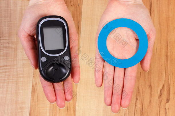 血糖仪和蓝色圆圈在手，<strong>糖尿病的</strong>象征