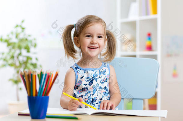 可爱的小女孩用彩色铅笔画画