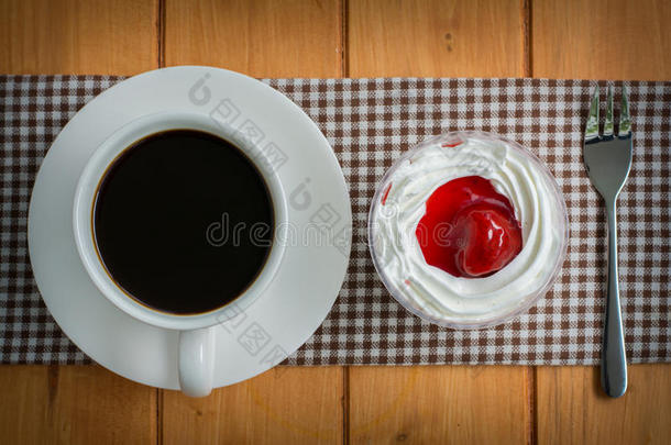 木制桌子上有<strong>草莓蛋糕</strong>的咖啡杯
