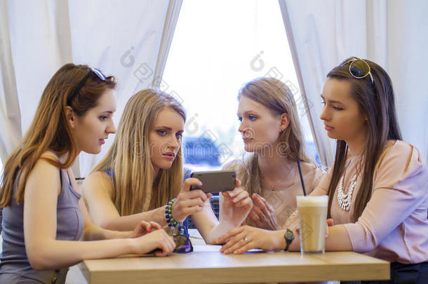一群年轻的女人<strong>围坐</strong>在桌子旁吃甜点