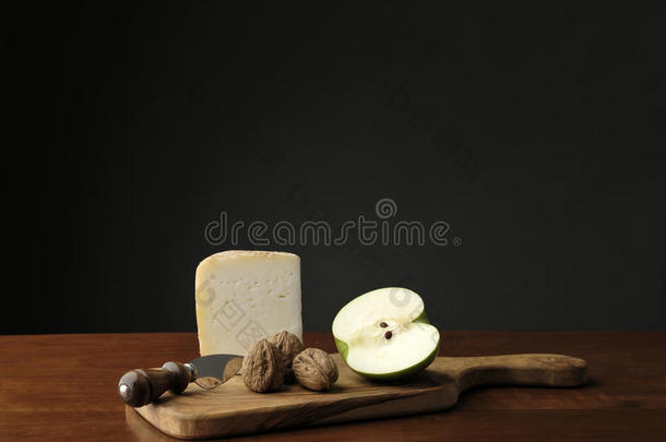 带奶酪和绿色苹果的切割板