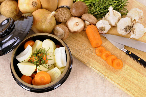 砂锅菜，有机蔬菜和草药在亚麻桌布，木材砧板