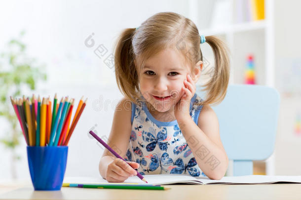 可爱的小学龄前儿童在家画画