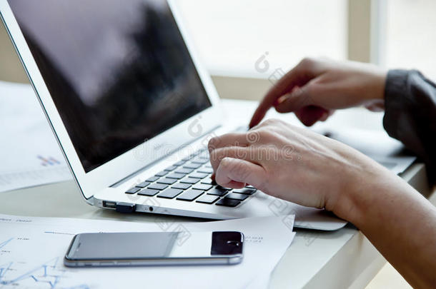 裁剪后的女商人形象，笔记本电脑写在办公桌上的笔记本上。