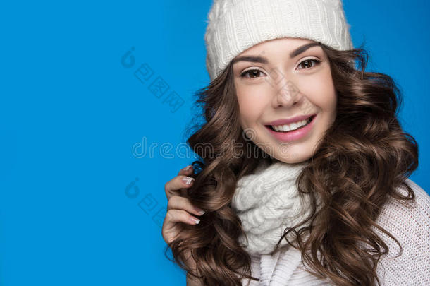 美丽的女孩，温柔的化妆，设计指甲和微笑白色针织帽。 温暖的冬天形象。 美丽的脸。