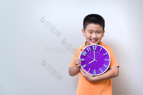 亚洲男孩在<strong>演播室</strong>里展示和拿着紫色或紫色的钟