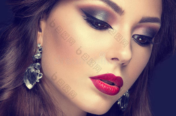美丽的女人，阿拉伯化妆，红唇和卷发。 美丽的脸。 不确定的颜色