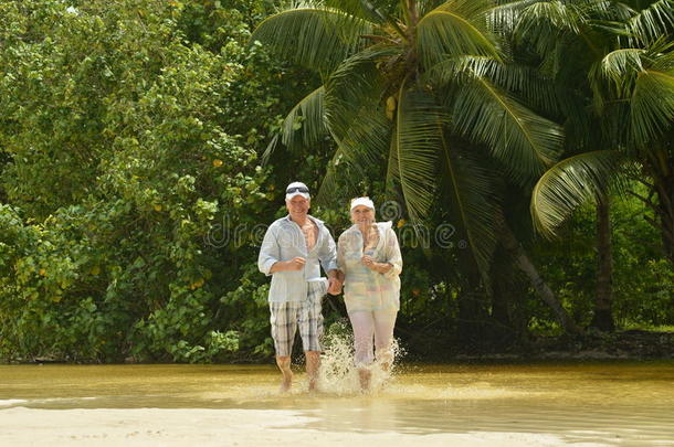 一对老年夫妇在海滩上跑步