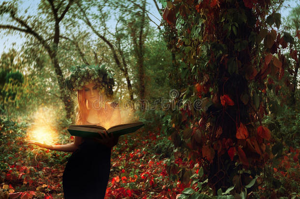 神奇的年轻女巫在树林里用一本神奇的书召唤