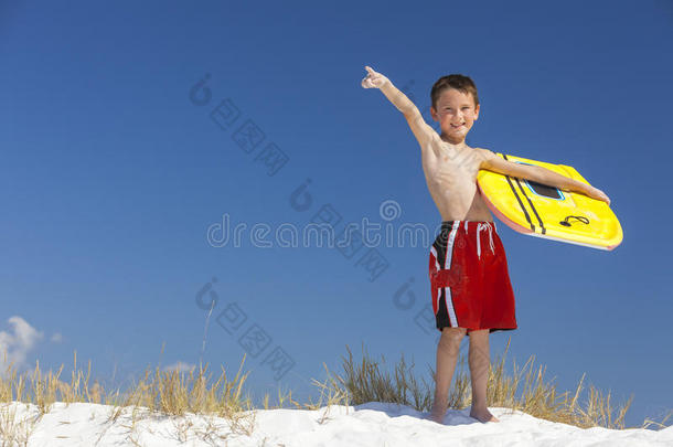 男孩男孩子用冲浪板指着海滩