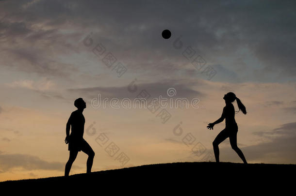 男孩和女孩在大自然中打排球。