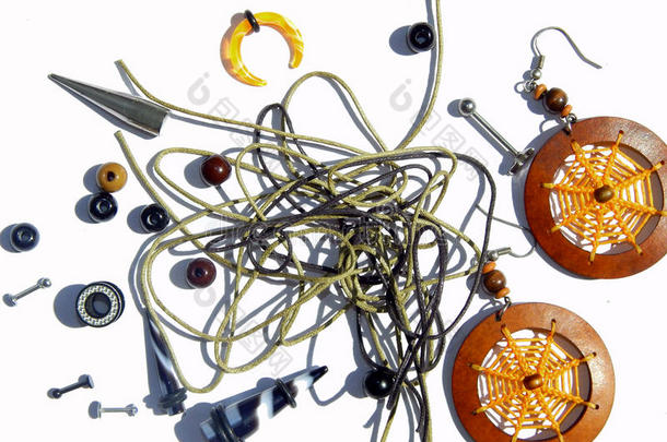 背景：穿孔耳环、橙色耳环、珠子、手镯绳