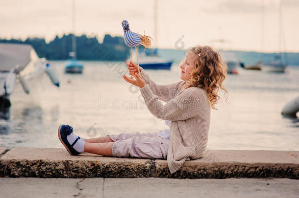 暑假在海边玩玩具鸟的女孩