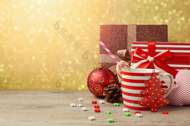 圣诞装饰品和杯子与礼品盒在金色博克背景