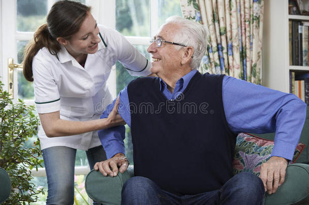 护理人员帮助老人从椅子上站起来