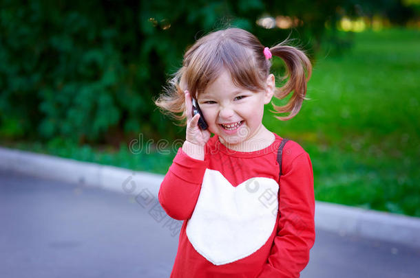 可爱小女孩打电话的户外写真