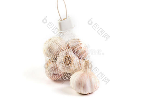 大蒜在网袋出售在市场上的白色背景
