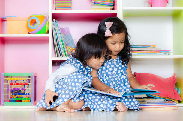 孩子读书，两个可爱的小女孩在一起看书