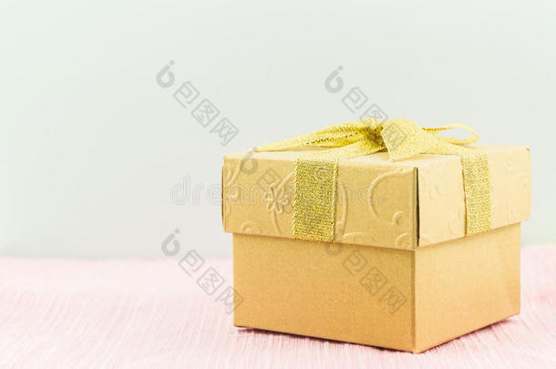 带丝带蝴蝶结的<strong>金色礼品</strong>盒。