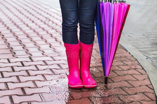秋天。雨中<strong>保护</strong>。穿粉红色胶靴，带彩色雨伞的<strong>妇女</strong>（女孩）。