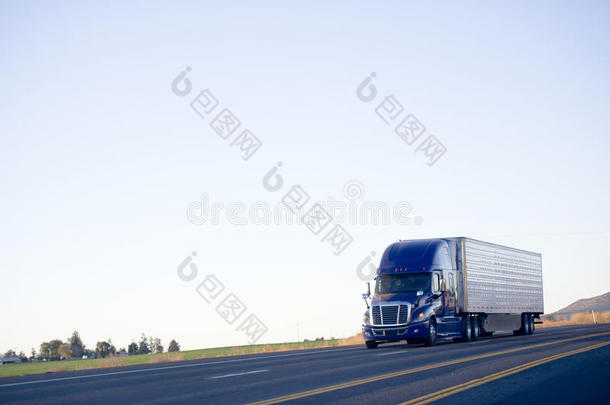 蓝色现代半卡车冷藏车在公路上运输货物