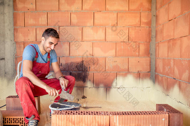 建筑梅森工人，砖匠建筑砖墙与抹子和砂浆
