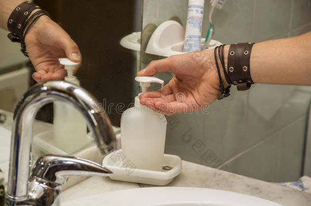 年轻人用液体肥皂洗手