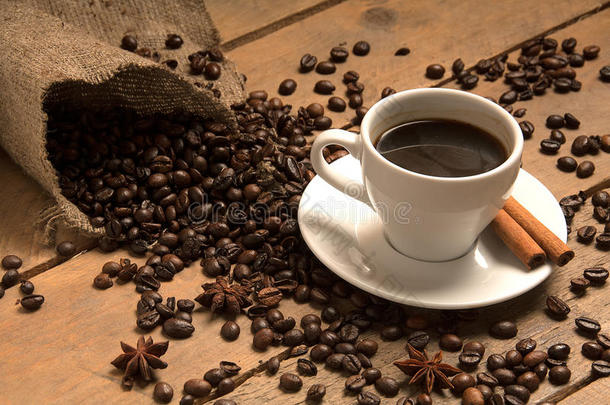 咖啡杯与咖啡豆牛角面包，肉桂在套袋和木材。