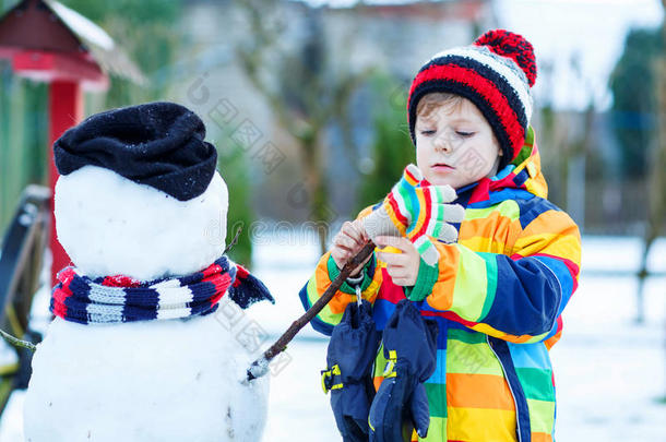 有趣的小男孩在冬天<strong>堆雪人</strong>