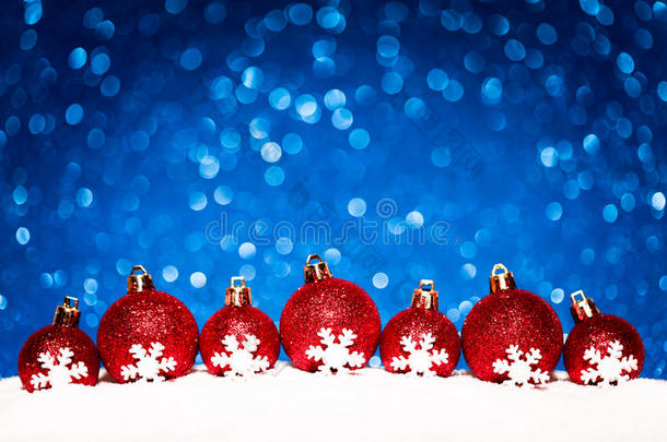圣诞<strong>红球</strong>在雪中的蓝色闪光