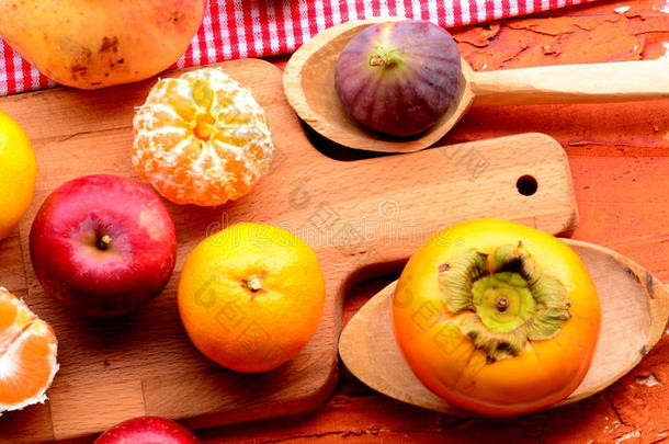 无花果，柿子，石榴，苹果和橘子（橘子）在粗糙的背景。 复古的主题