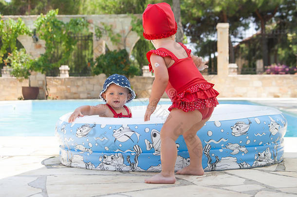 一个快乐的孩子正在婴儿游泳池外面玩耍