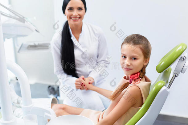 牙医和牙医办公室的病人。 孩子在牙科椅子上