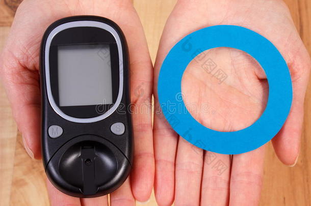 血糖仪和蓝色圆圈在手，<strong>糖尿病的</strong>象征