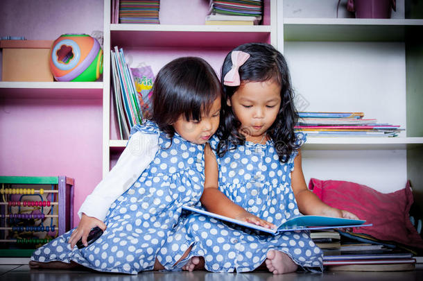 孩子读书，两个可爱的小女孩在书上一起看书