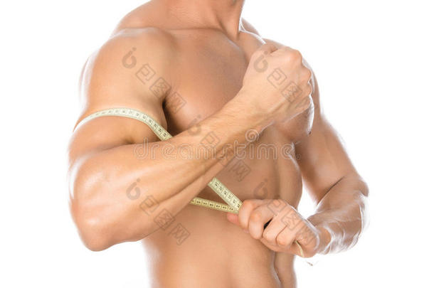 健美和运动主题：英俊强壮的健美运动员拿着厘米的磁带测量白色背景上的身体