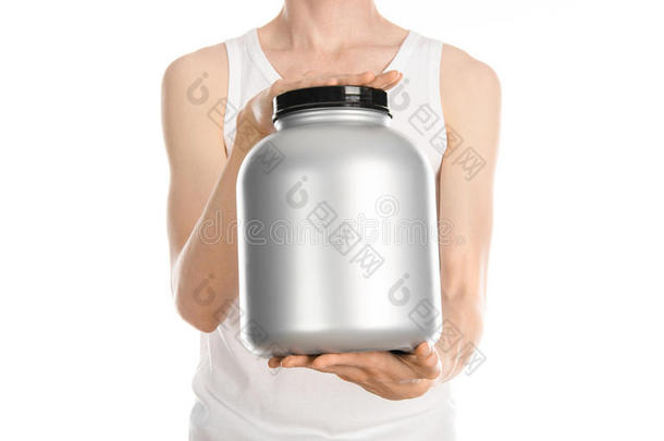 健美和运动主题：一个穿着白色t恤和牛仔裤的瘦男人拿着一个塑料罐，里面有一种蛋白质在白色的ba上分离出来