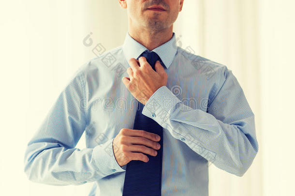 贴身男人穿着衬衫调整领带在脖子上