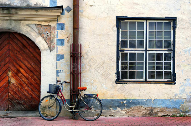 自行车站在一个有方形窗户的老房子的门口