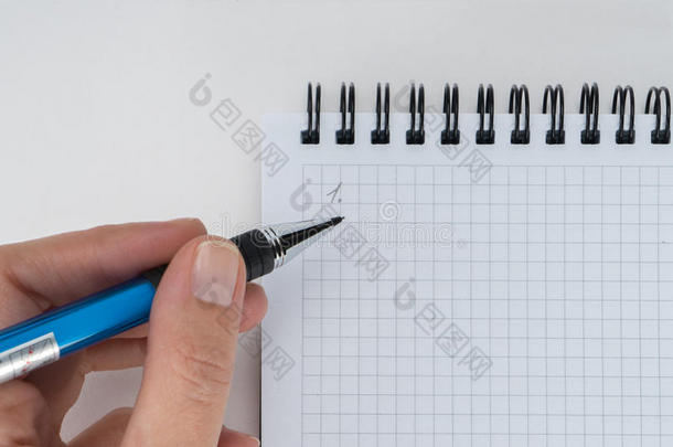 一只手在空白的笔记本上写字
