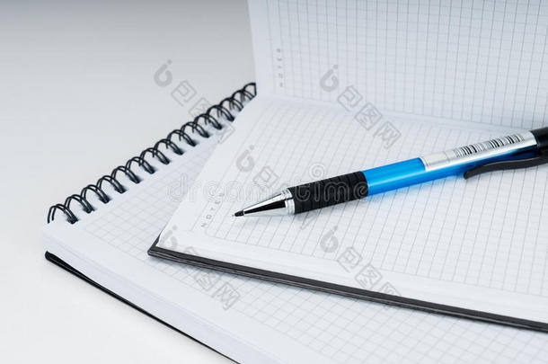 白色背景上的空白螺旋笔记本、记事本和钢笔
